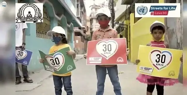 Children hold heart-shaped "30" speed-limit placards during the UN Global Road Safety Week.